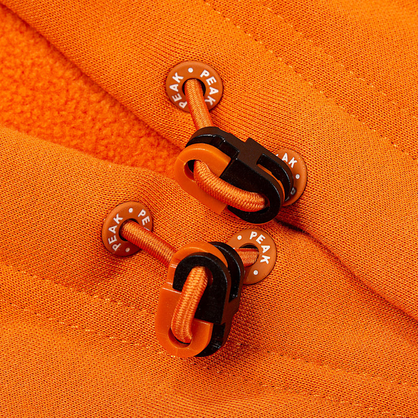 Sweat à capuche orange PEAK Live For Now pour homme, avec imprimé graphique de baskets et logo PEAK sur la poitrine – style moderne, confortable et idéal pour le quotidien.