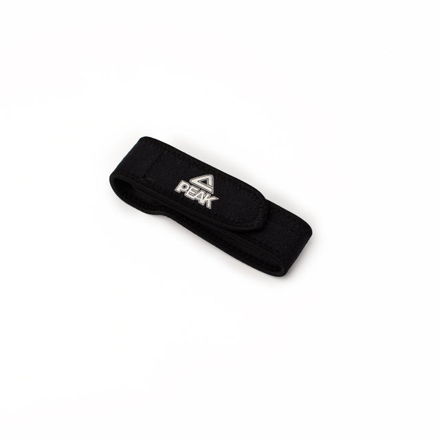Brace de genou PEAK noir avec sangle de maintien rotulienne ajustable. Aide à stabiliser le genou et réduire la douleur pendant le sport.